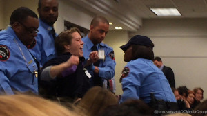 Security drags protestor Sean Glenn out of the FERC meeting.
