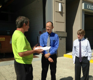 Ted Glick, left, speaks to FERC Chairman Norman Bay and an assistant.