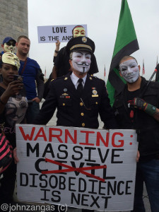 Retired police chief Ray Lewis dons a Guy Fawkes mask and makes a statement./Photo by John Zangas