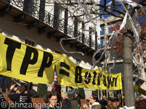 Toilet paper streams from trees and protesters hold banners at the U.S. Trade Representative building.