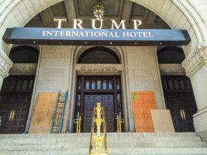 Spraypainted slogans "Black Lives Matter" and "No Justice [No] Peace" were covered with plywood at the side entrance of Trump International Hotel./Photo by Anne Meador